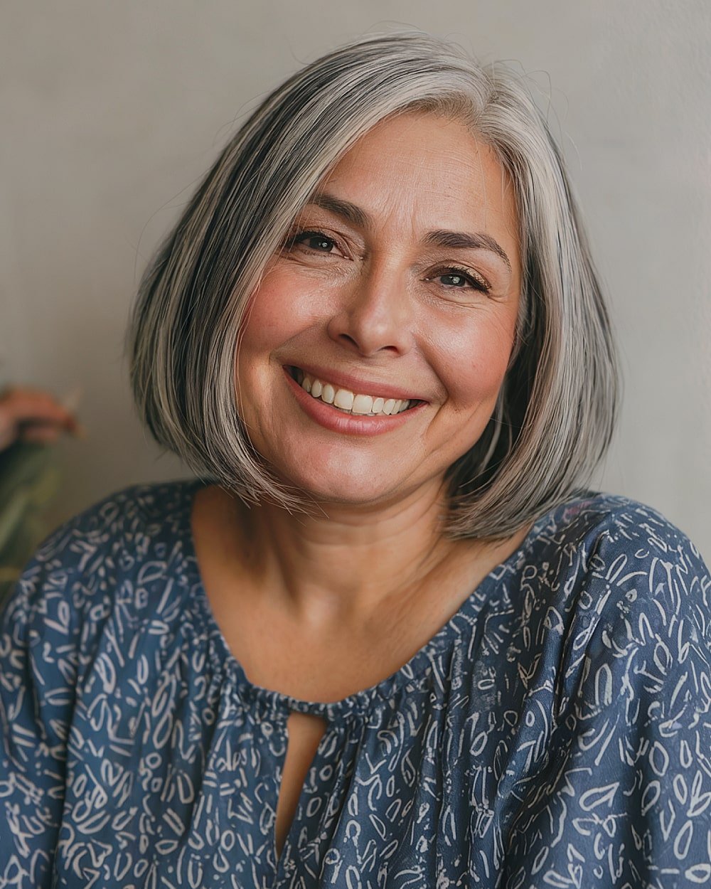 Chin-length ash grey bob with subtle highlights, blending natural greys into dark straight hair for sleek refinement
